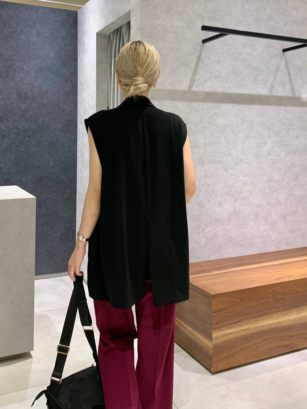 ブラック系のスリッポン、ホワイト系のキャミソール、ブラック系のボディバッグ/ウエストポーチを着用したレディースの夏コーディネートの2枚目の写真