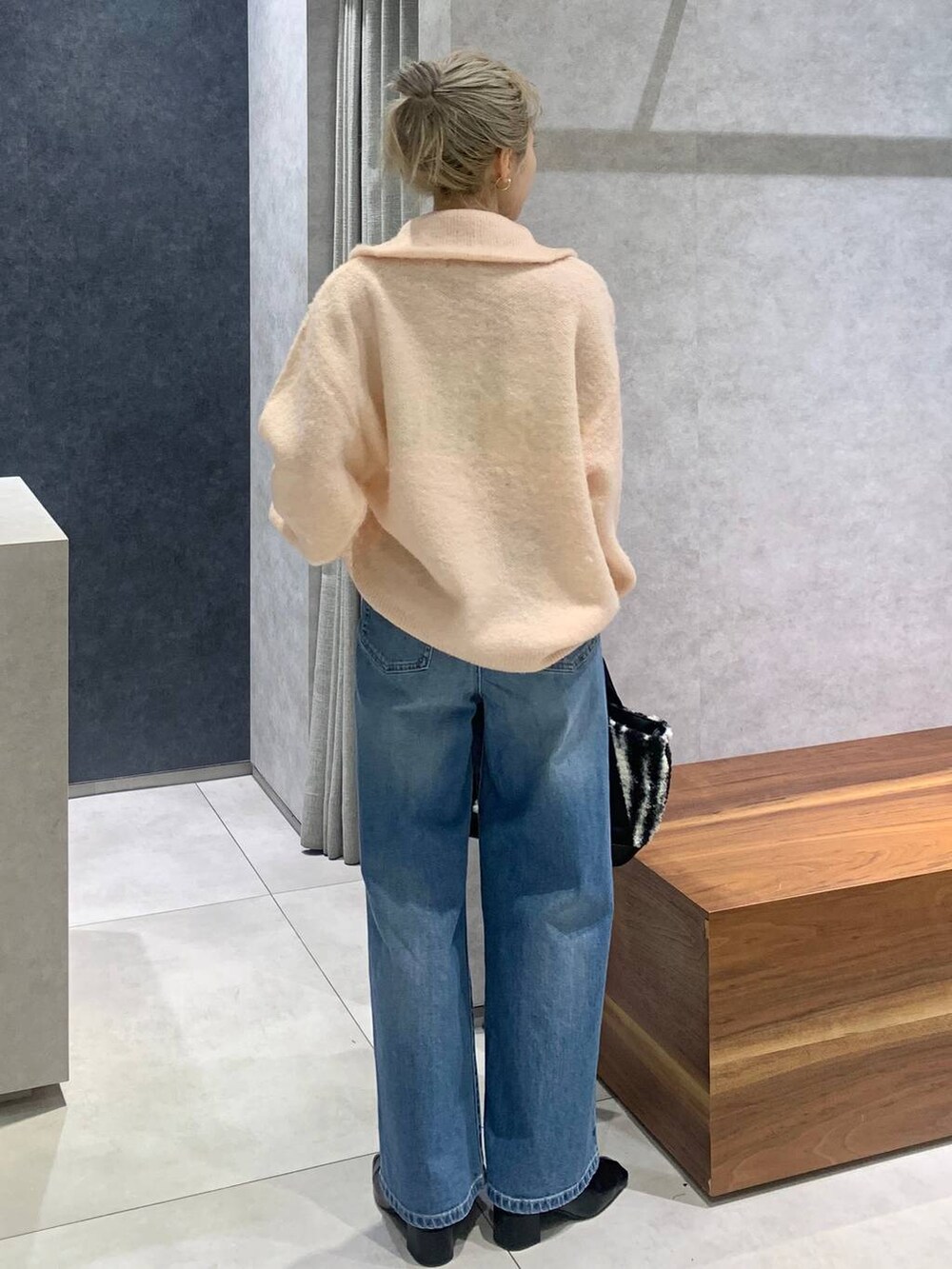 ブルー系のデニムパンツ、ホワイト系のトートバッグ、ピンク系のカーディガン/ボレロを着用したレディースの冬コーディネートの3枚目の写真
