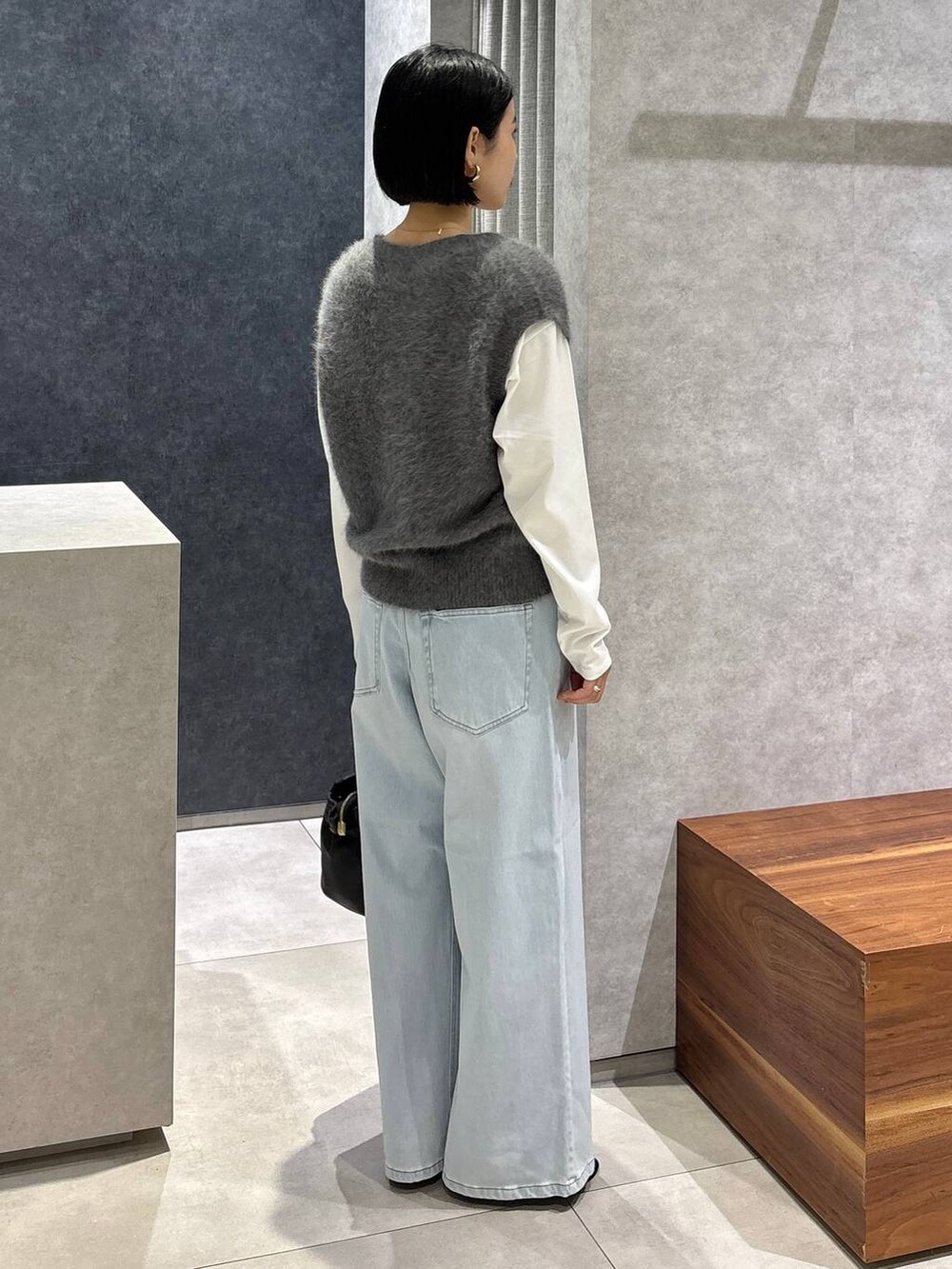ブラック系のショルダーバッグ、ブルー系のデニムパンツ、ホワイト系のTシャツ/カットソーを着用したレディースの夏コーディネートの3枚目の写真