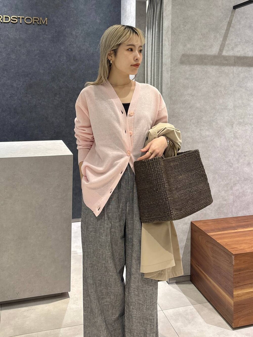 ブラウン系のかごバッグ、グレー系のその他パンツ、ピンク系のカーディガン/ボレロを着用したレディースの春コーディネートの3枚目の写真