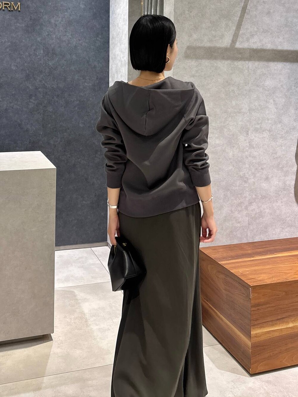 ブラック系のハンドバッグ、グリーン系のタンクトップ、グリーン系のスカートを着用したレディースの夏コーディネートの5枚目の写真