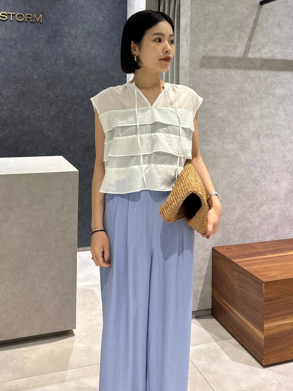 ブラウン系のトートバッグ、ブラック系のキャミソール、ブラック系のサンダルを着用したレディースの春コーディネートの3枚目の写真