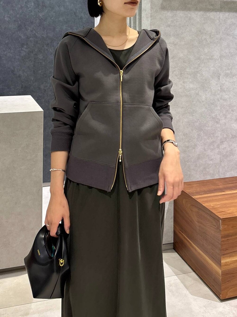 ブラック系のハンドバッグ、グリーン系のタンクトップ、グリーン系のスカートを着用したレディースの夏コーディネートの6枚目の写真