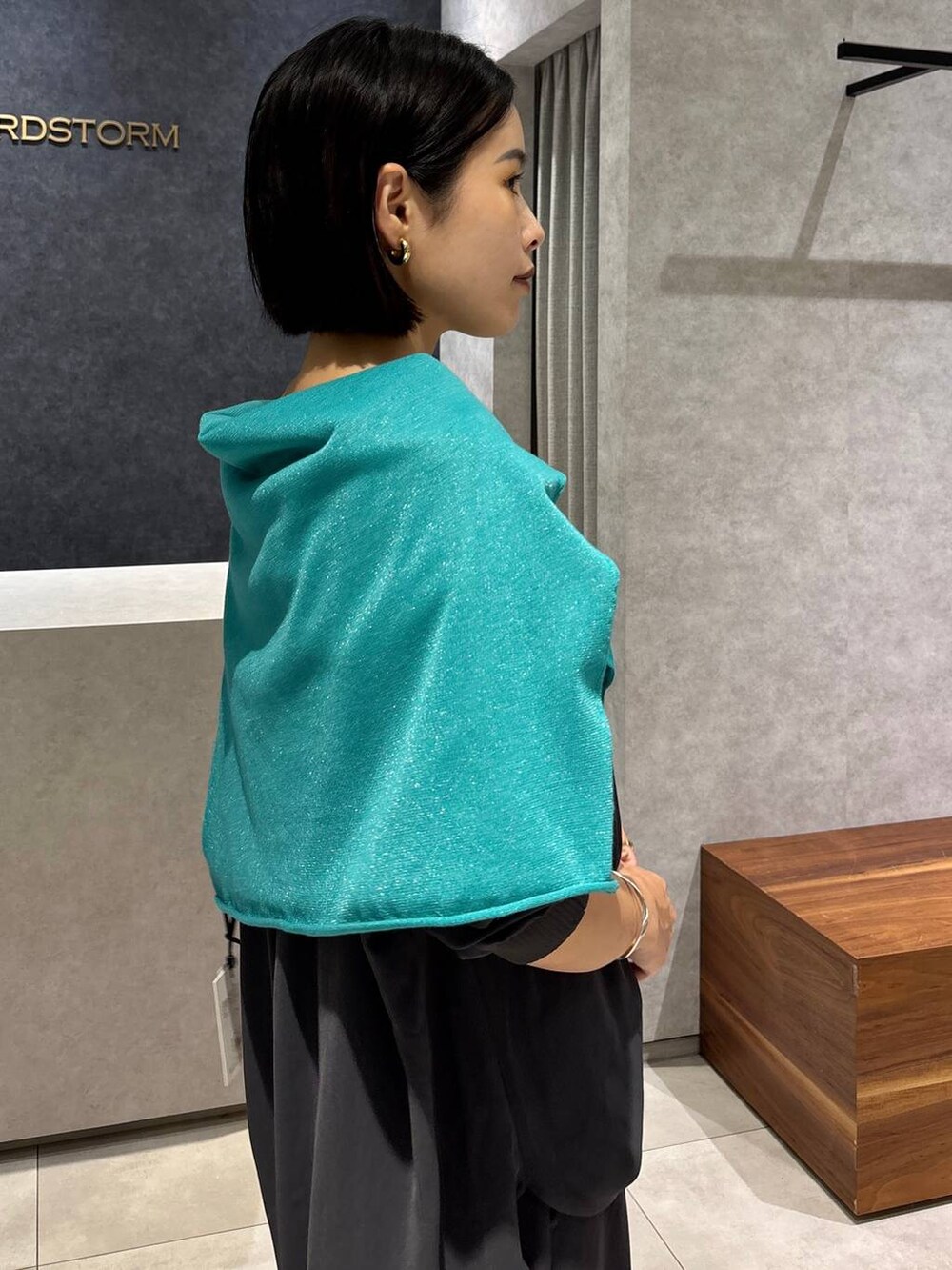 グレー系のシャツ/ブラウス、グレー系のスラックス、グリーン系のニット/セーターを着用したレディースの夏コーディネートの6枚目の写真