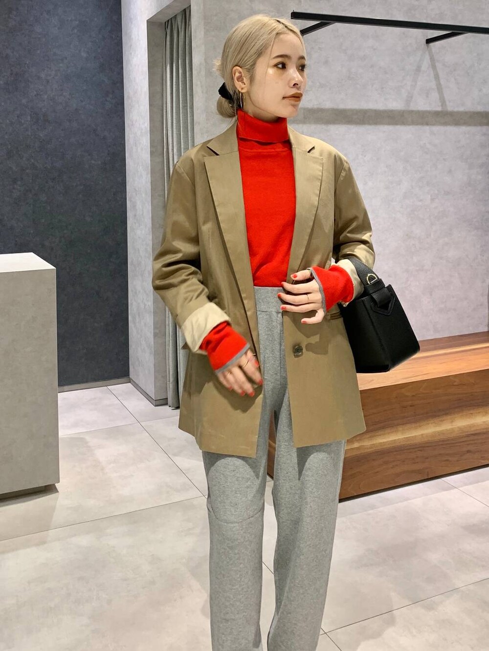 ブラック系のハンドバッグ、ベージュ系のテーラードジャケット、ブラック系のパンプスを着用したレディースの秋コーディネートの3枚目の写真