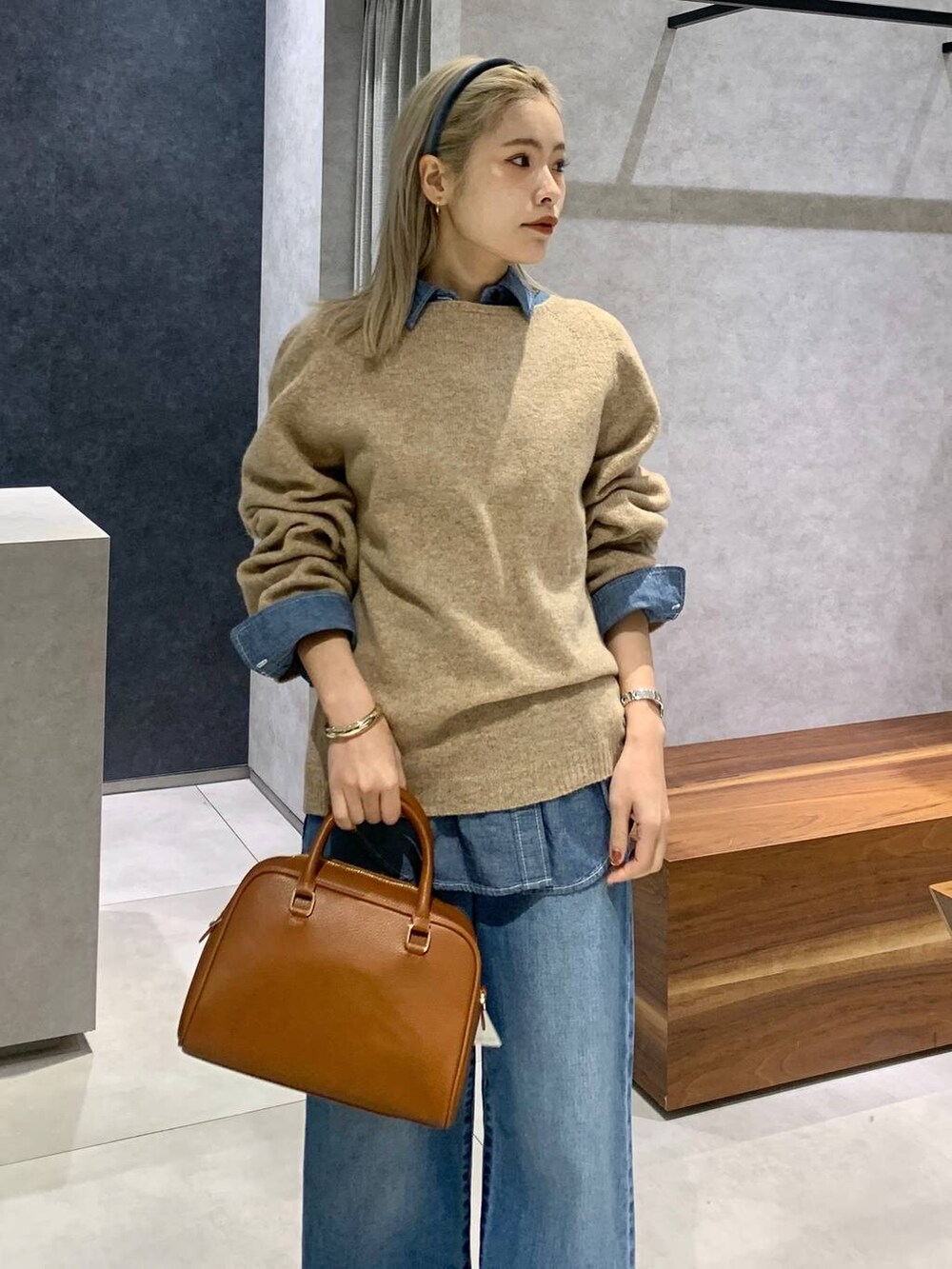 ブルー系のデニムパンツ、ブルー系のシャツ/ブラウス、イエロー系のボストンバッグを着用したレディースの冬コーディネートの3枚目の写真