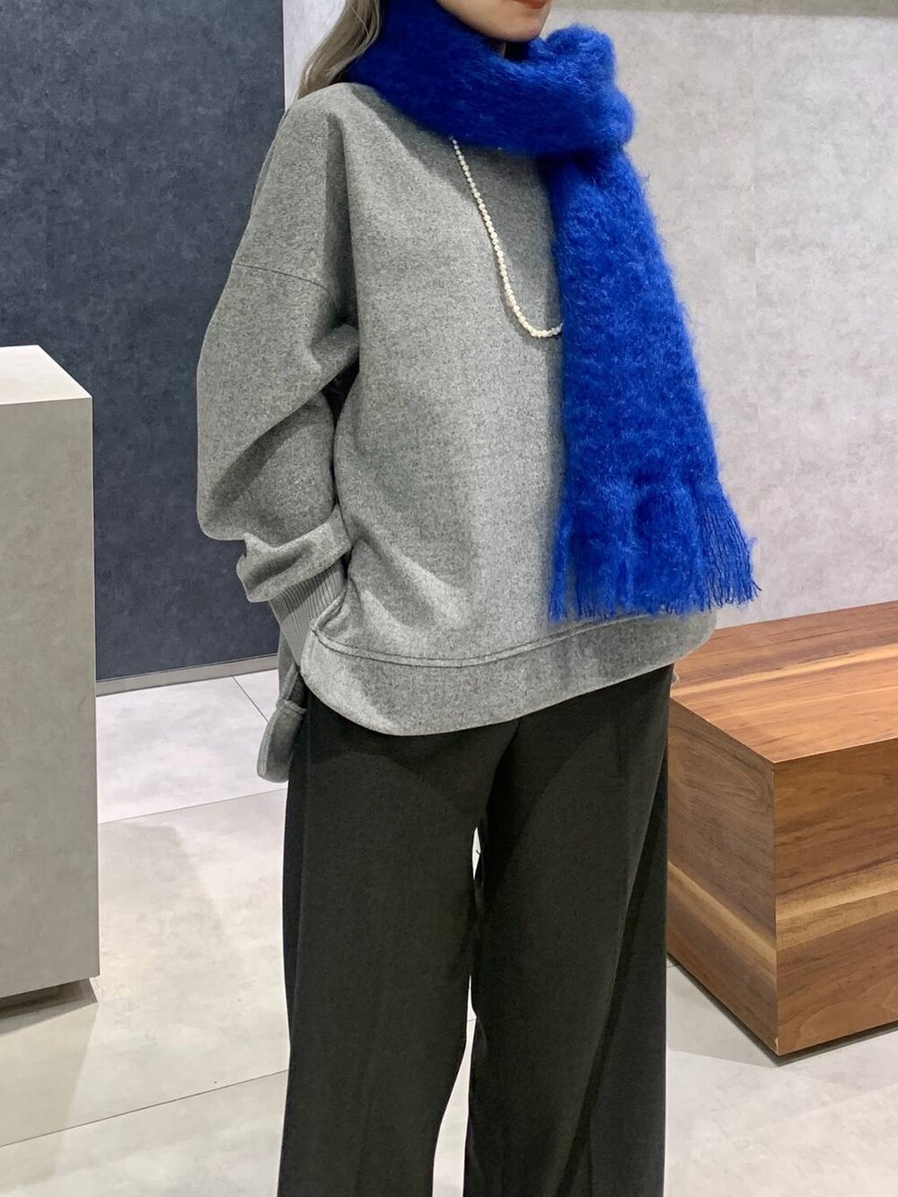 グレー系のパーカー、グレー系のトートバッグ、ブラック系のローファーを着用したレディースの秋コーディネートの3枚目の写真