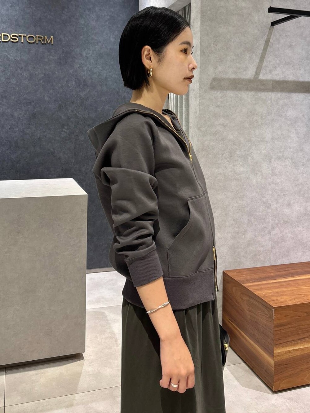 ブラック系のハンドバッグ、グリーン系のタンクトップ、グリーン系のスカートを着用したレディースの夏コーディネートの4枚目の写真