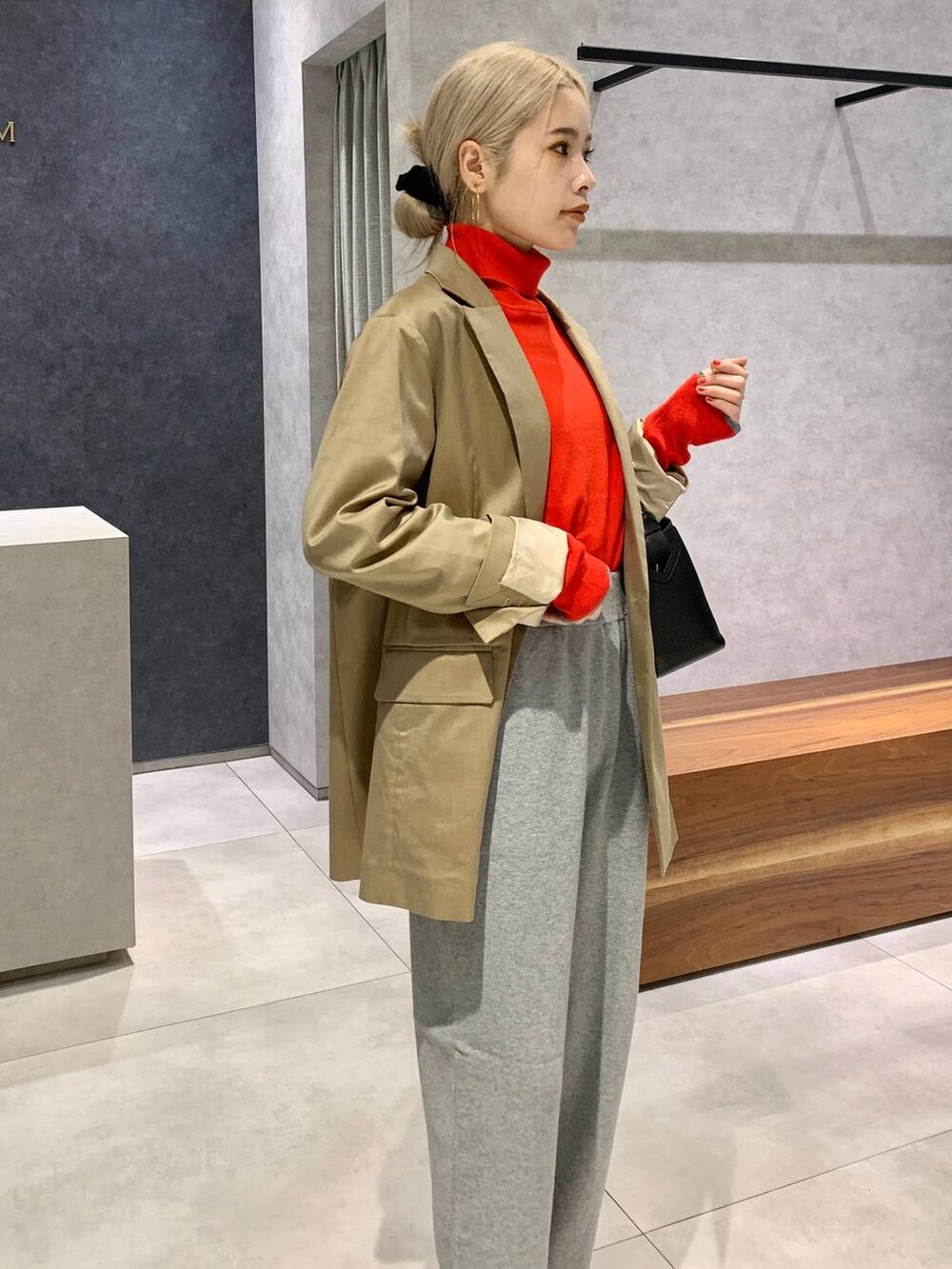 ブラック系のハンドバッグ、ベージュ系のテーラードジャケット、ブラック系のパンプスを着用したレディースの秋コーディネートの4枚目の写真