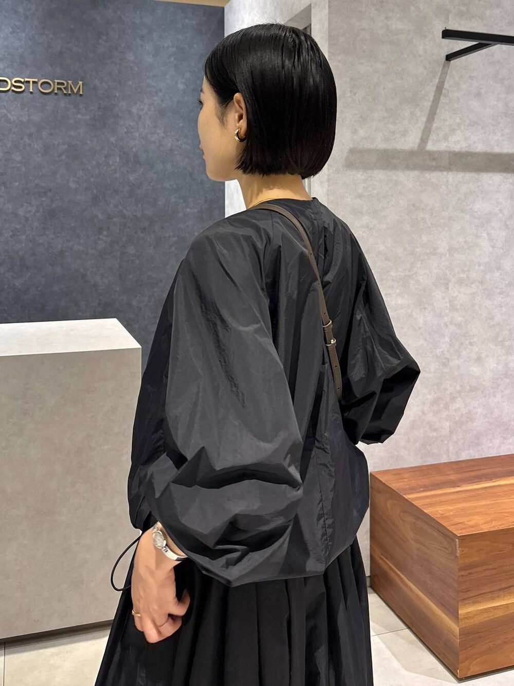 ブラック系のスカート、ブラック系のブルゾン、ブラウン系のショルダーバッグを着用したレディースの夏コーディネートの6枚目の写真