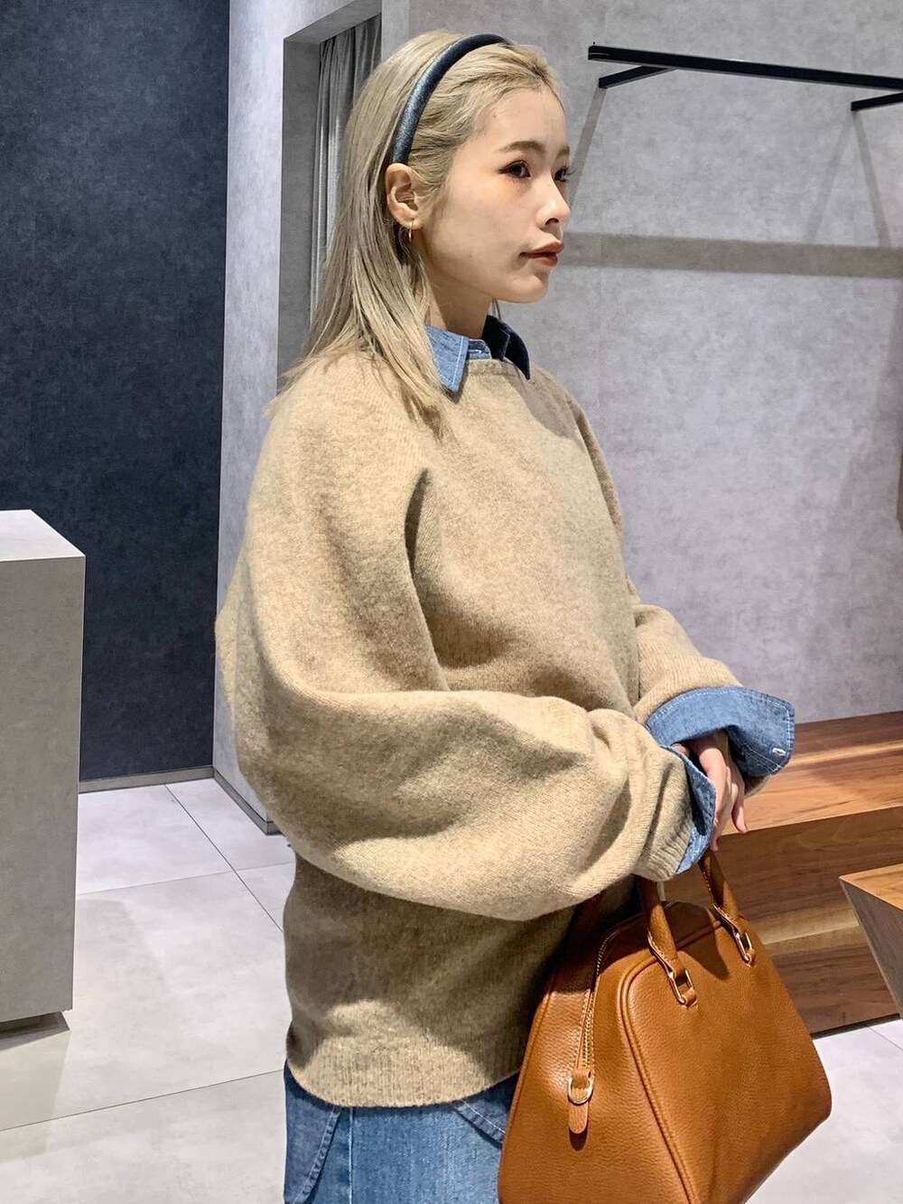 ブルー系のデニムパンツ、ブルー系のシャツ/ブラウス、イエロー系のボストンバッグを着用したレディースの冬コーディネートの5枚目の写真
