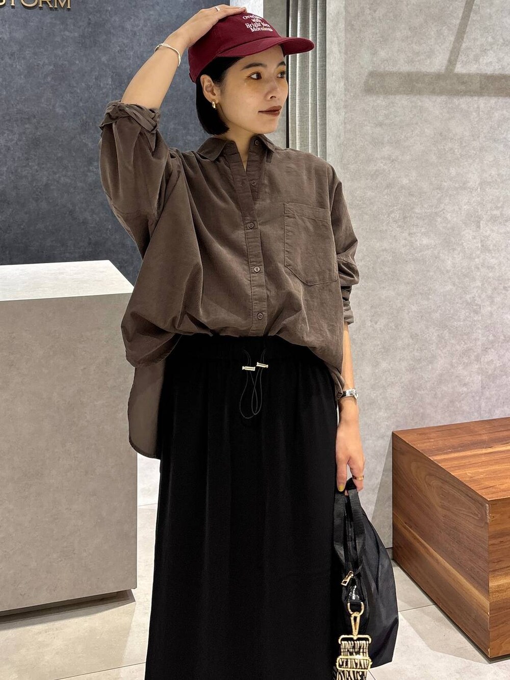 ブラック系のローファー、ブラック系のトートバッグ、ブラック系のスカートを着用したレディースの夏コーディネートの7枚目の写真