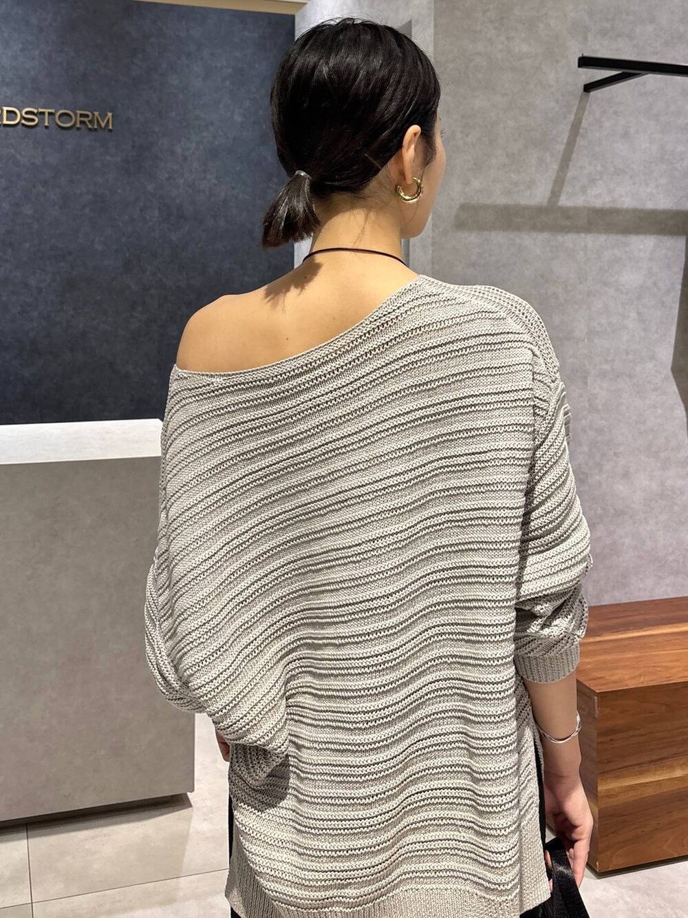 グレー系のニット/セーター、グレー系のトートバッグ、ブラック系のサンダルを着用したレディースの夏コーディネートの5枚目の写真