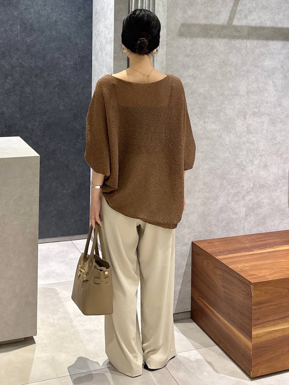 ブラウン系のニット/セーター、ベージュ系のショルダーバッグ、ホワイト系のその他パンツを着用したレディースの夏コーディネートの4枚目の写真