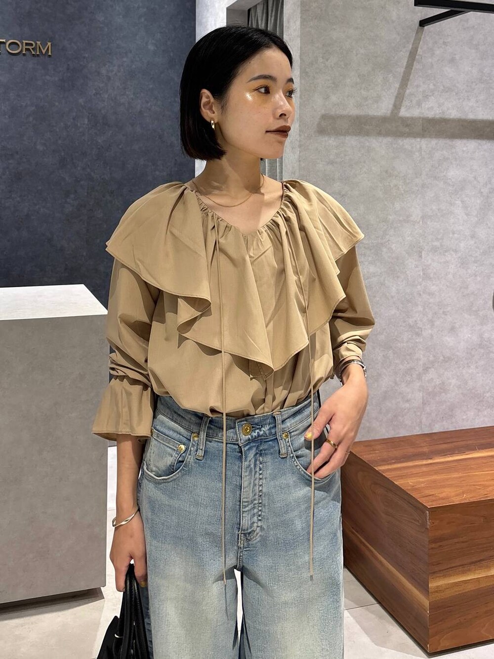 ブルー系のデニムパンツ、ブラック系のローファー、ブラック系のショルダーバッグを着用したレディースの夏コーディネートの5枚目の写真