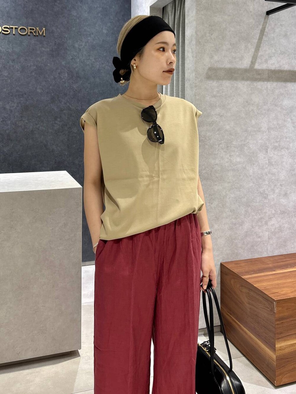 レッド系のその他パンツ、ベージュ系のTシャツ/カットソー、ブラック系のサンダルを着用したレディースの春コーディネートの5枚目の写真