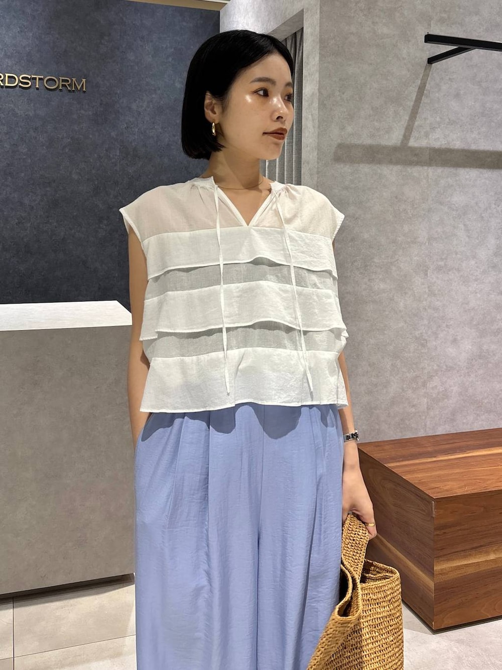 ブラウン系のトートバッグ、ブラック系のキャミソール、ブラック系のサンダルを着用したレディースの春コーディネートの4枚目の写真