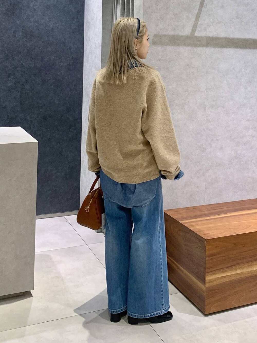 ブルー系のデニムパンツ、ブルー系のシャツ/ブラウス、イエロー系のボストンバッグを着用したレディースの冬コーディネートの2枚目の写真