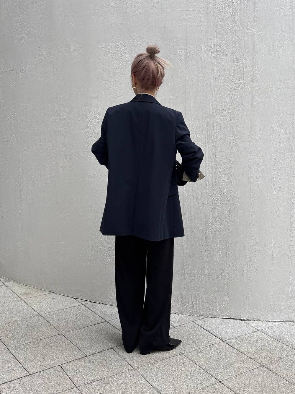 ブラック系のショルダーバッグ、ブラック系のスラックス、ブルー系のテーラードジャケットを着用したレディースの冬コーディネートの2枚目の写真