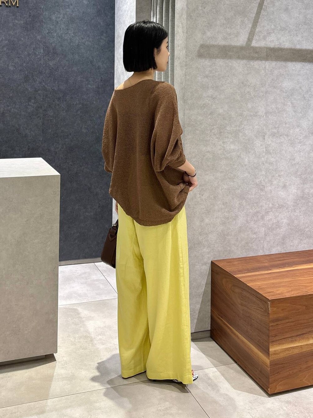 ブラウン系のハンドバッグ、ブラック系のキャミソール、ブラウン系のニット/セーターを着用したレディースの春コーディネートの4枚目の写真