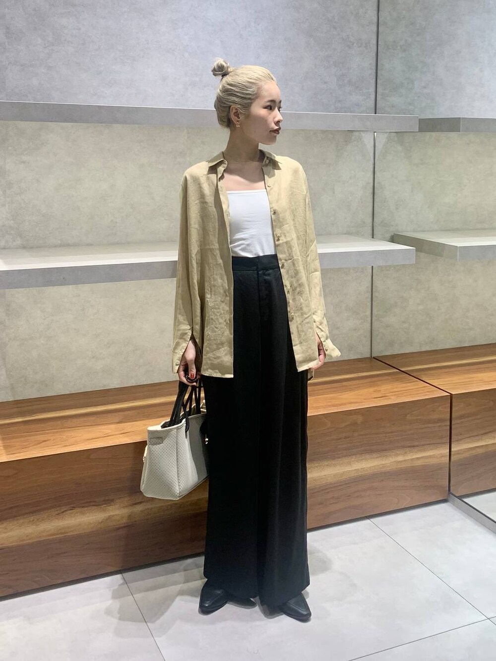 ベージュ系のトートバッグ、ブラック系のローファー、ベージュ系のシャツ/ブラウスを着用したレディースの夏コーディネートの2枚目の写真