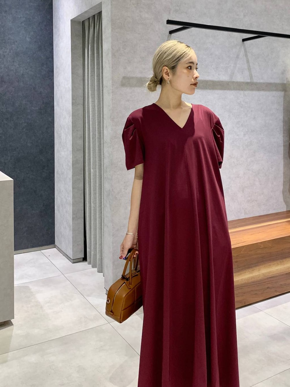 ブラック系のスリッポン、ブラウン系のハンドバッグ、レッド系のワンピースを着用したレディースの夏コーディネートの4枚目の写真