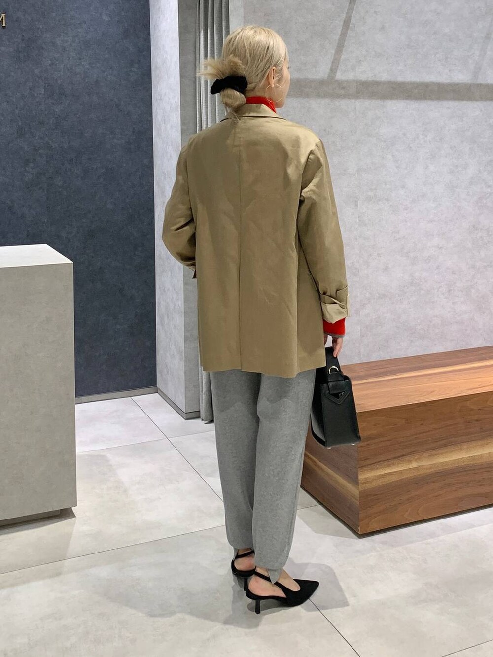 ブラック系のハンドバッグ、ベージュ系のテーラードジャケット、ブラック系のパンプスを着用したレディースの秋コーディネートの2枚目の写真