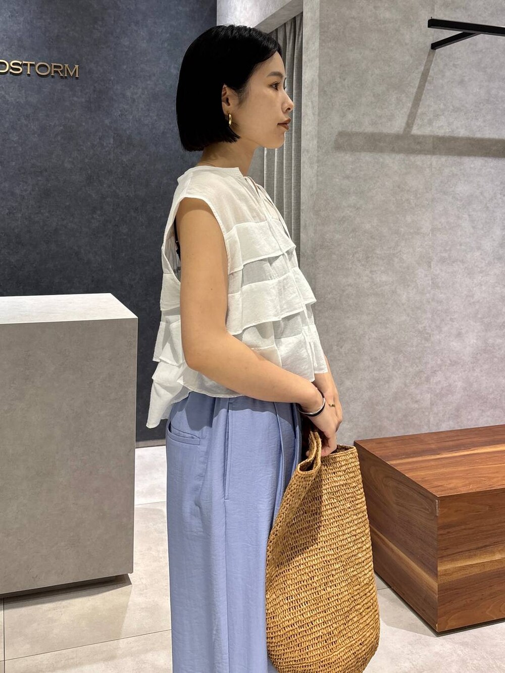 ブラウン系のトートバッグ、ブラック系のキャミソール、ブラック系のサンダルを着用したレディースの春コーディネートの5枚目の写真