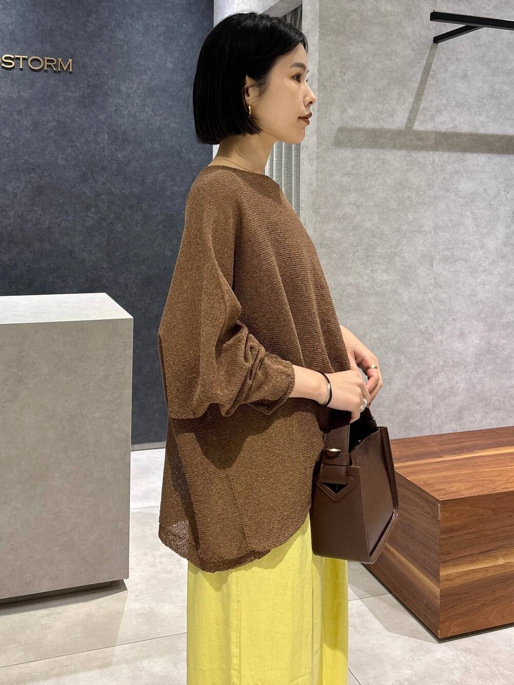 ブラウン系のハンドバッグ、ブラック系のキャミソール、ブラウン系のニット/セーターを着用したレディースの春コーディネートの6枚目の写真