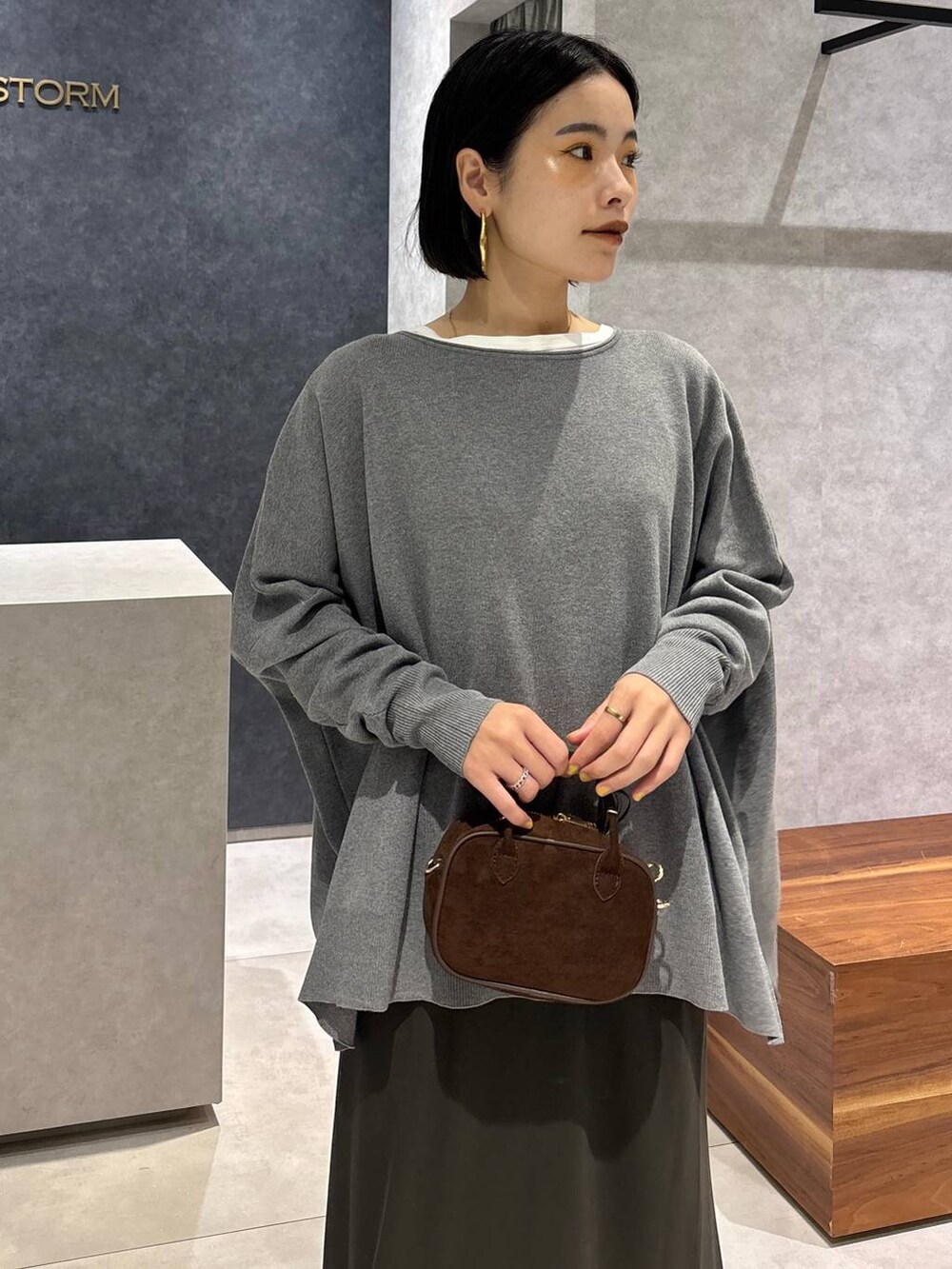 グリーン系のスカート、ホワイト系のTシャツ/カットソー、ブラウン系のショルダーバッグを着用したレディースの夏コーディネートの9枚目の写真