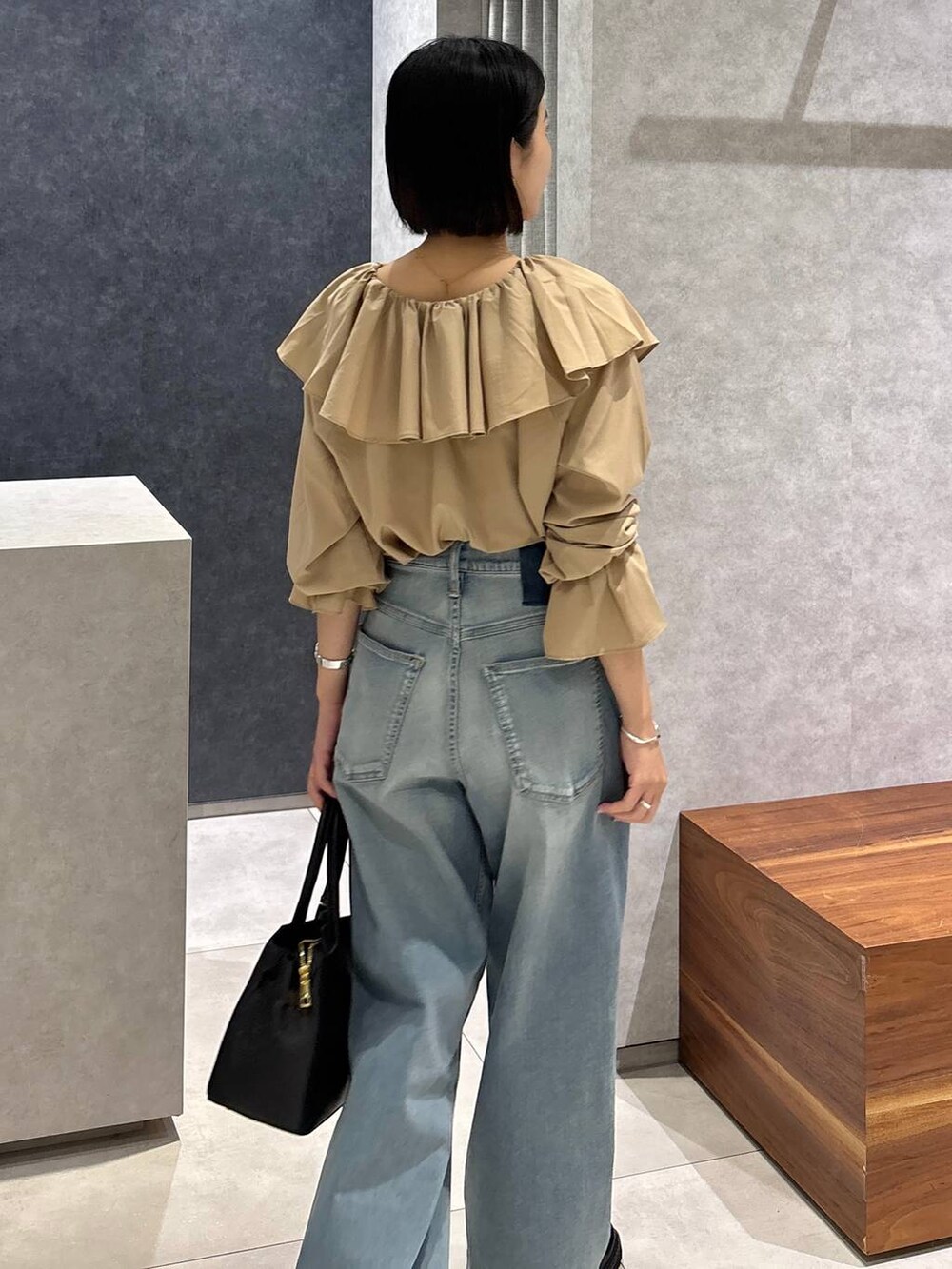 ブルー系のデニムパンツ、ブラック系のローファー、ブラック系のショルダーバッグを着用したレディースの夏コーディネートの8枚目の写真