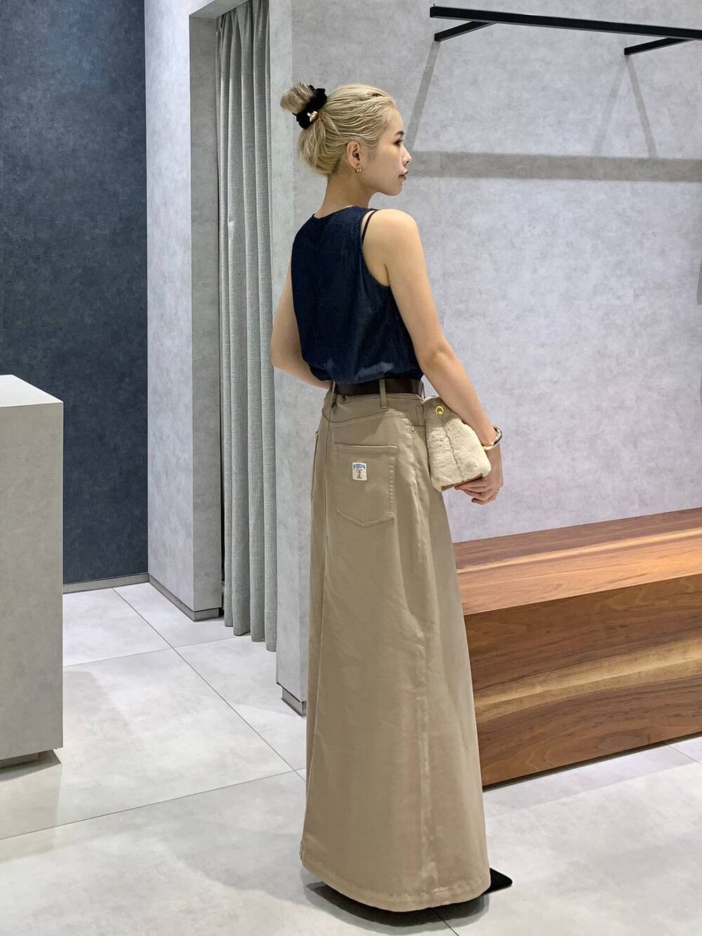 ホワイト系のショルダーバッグ、ブルー系のシャツ/ブラウス、ブラウン系のスカートを着用したレディースの夏コーディネートの2枚目の写真