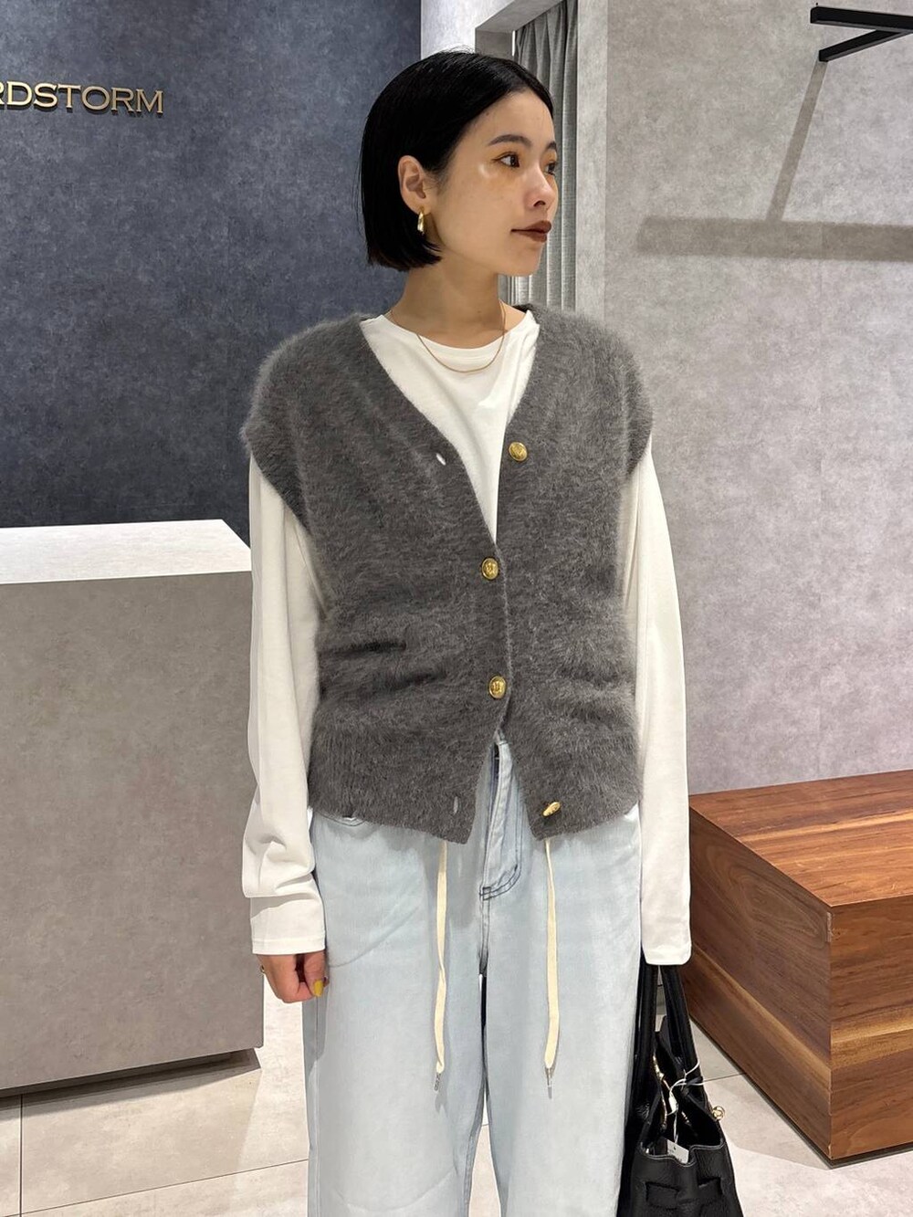 ブラック系のショルダーバッグ、ブルー系のデニムパンツ、ホワイト系のTシャツ/カットソーを着用したレディースの夏コーディネートの4枚目の写真