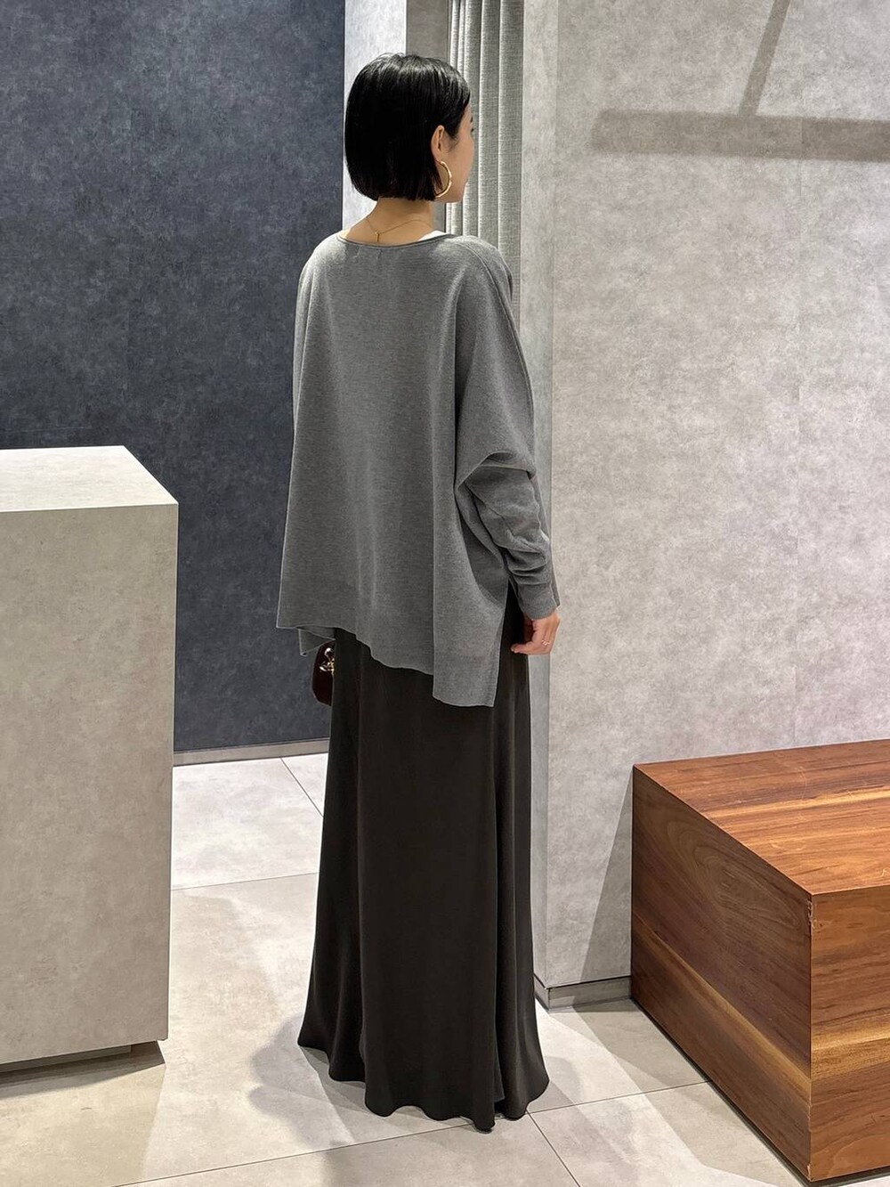 グリーン系のスカート、ホワイト系のTシャツ/カットソー、ブラウン系のショルダーバッグを着用したレディースの夏コーディネートの3枚目の写真