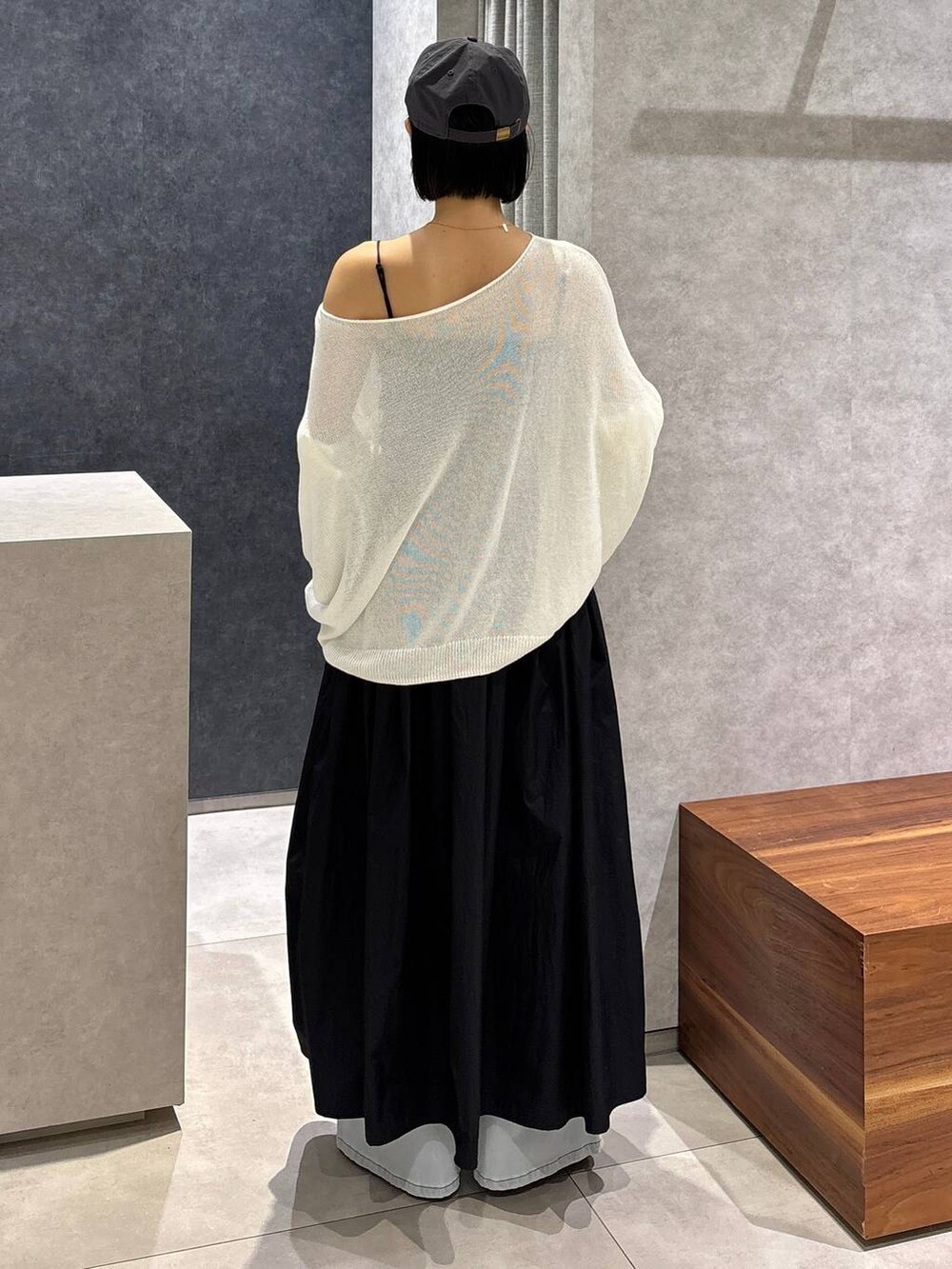 ブルー系のデニムパンツ、ブルー系のトートバッグ、ホワイト系のニット/セーターを着用したレディースの夏コーディネートの3枚目の写真