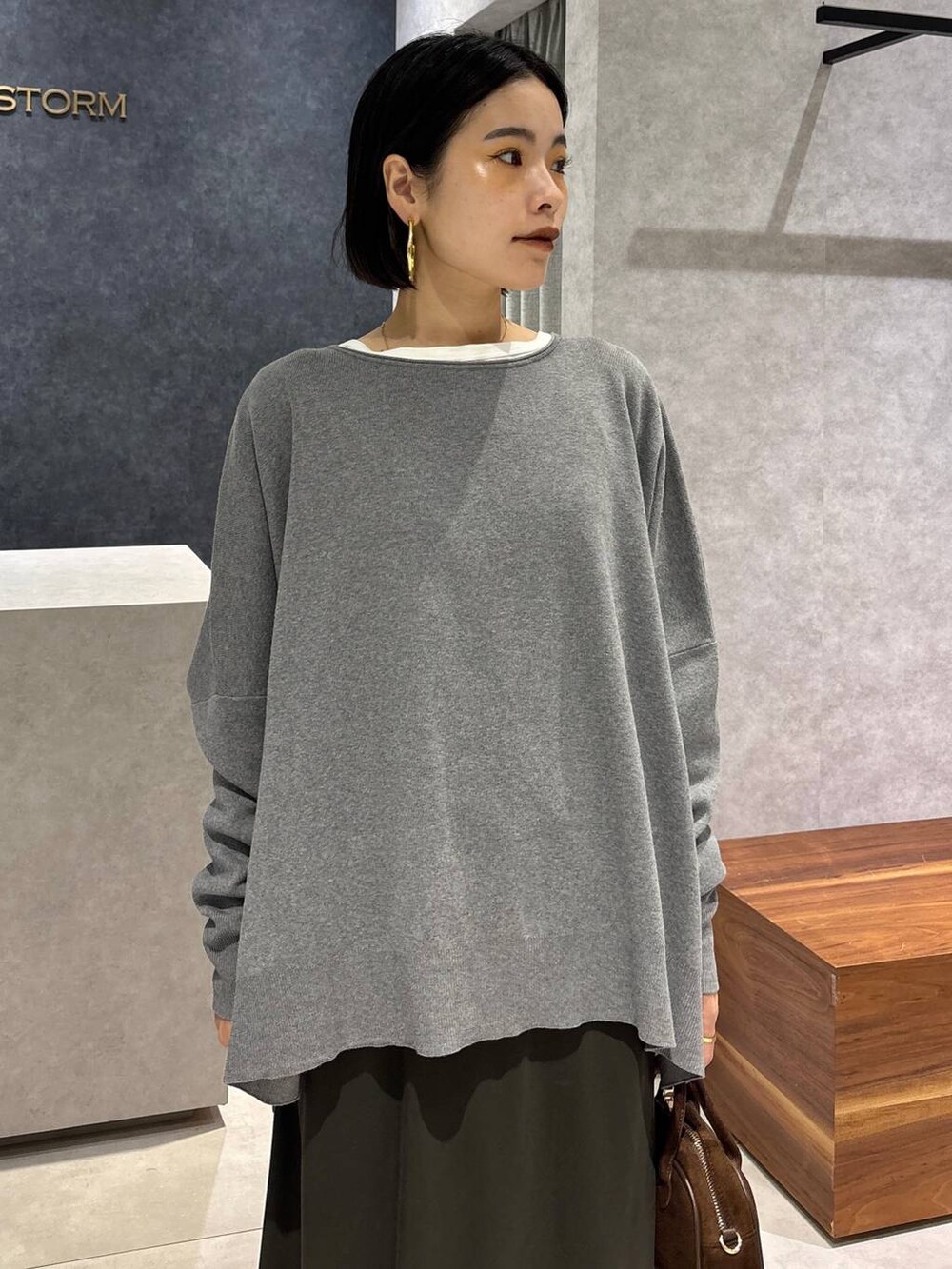 グリーン系のスカート、ホワイト系のTシャツ/カットソー、ブラウン系のショルダーバッグを着用したレディースの夏コーディネートの5枚目の写真