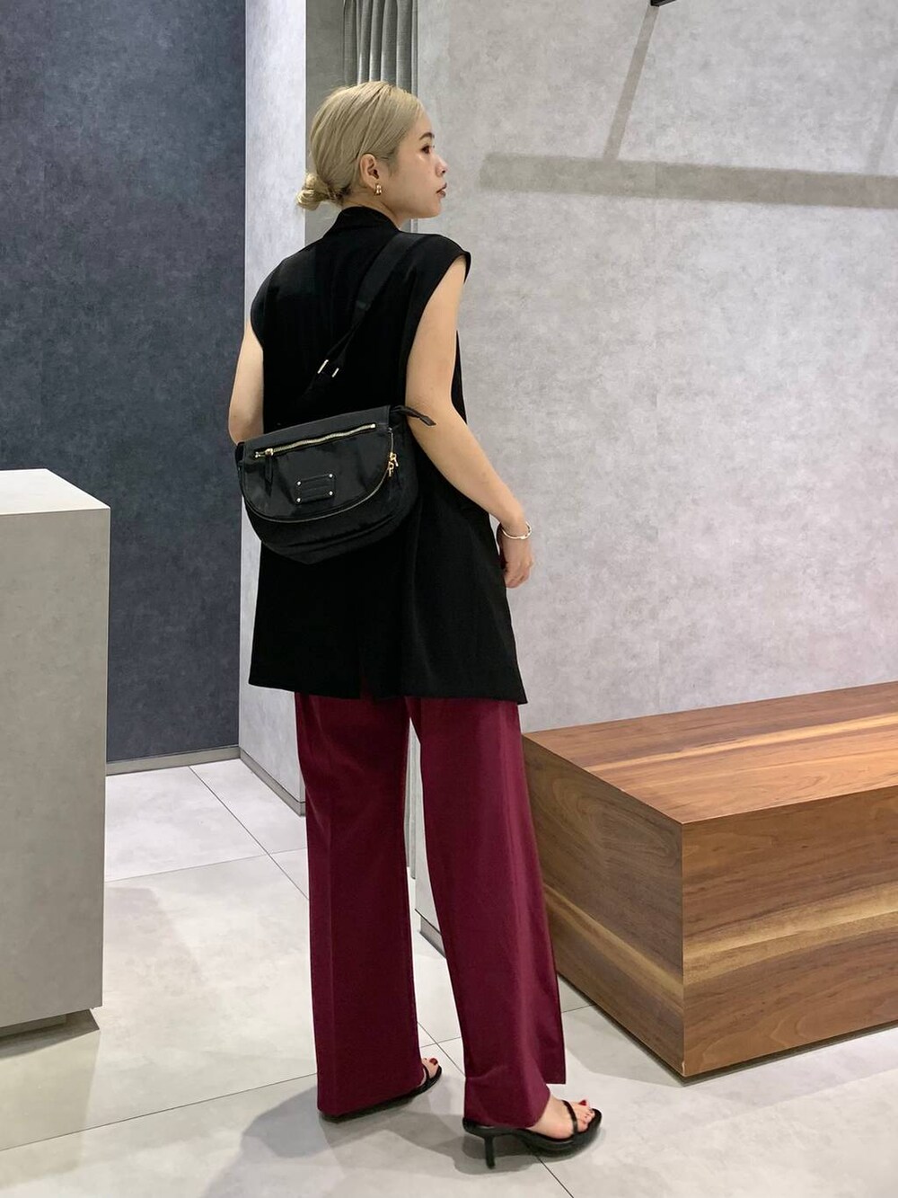 ブラック系のスリッポン、ホワイト系のキャミソール、ブラック系のボディバッグ/ウエストポーチを着用したレディースの夏コーディネートの3枚目の写真