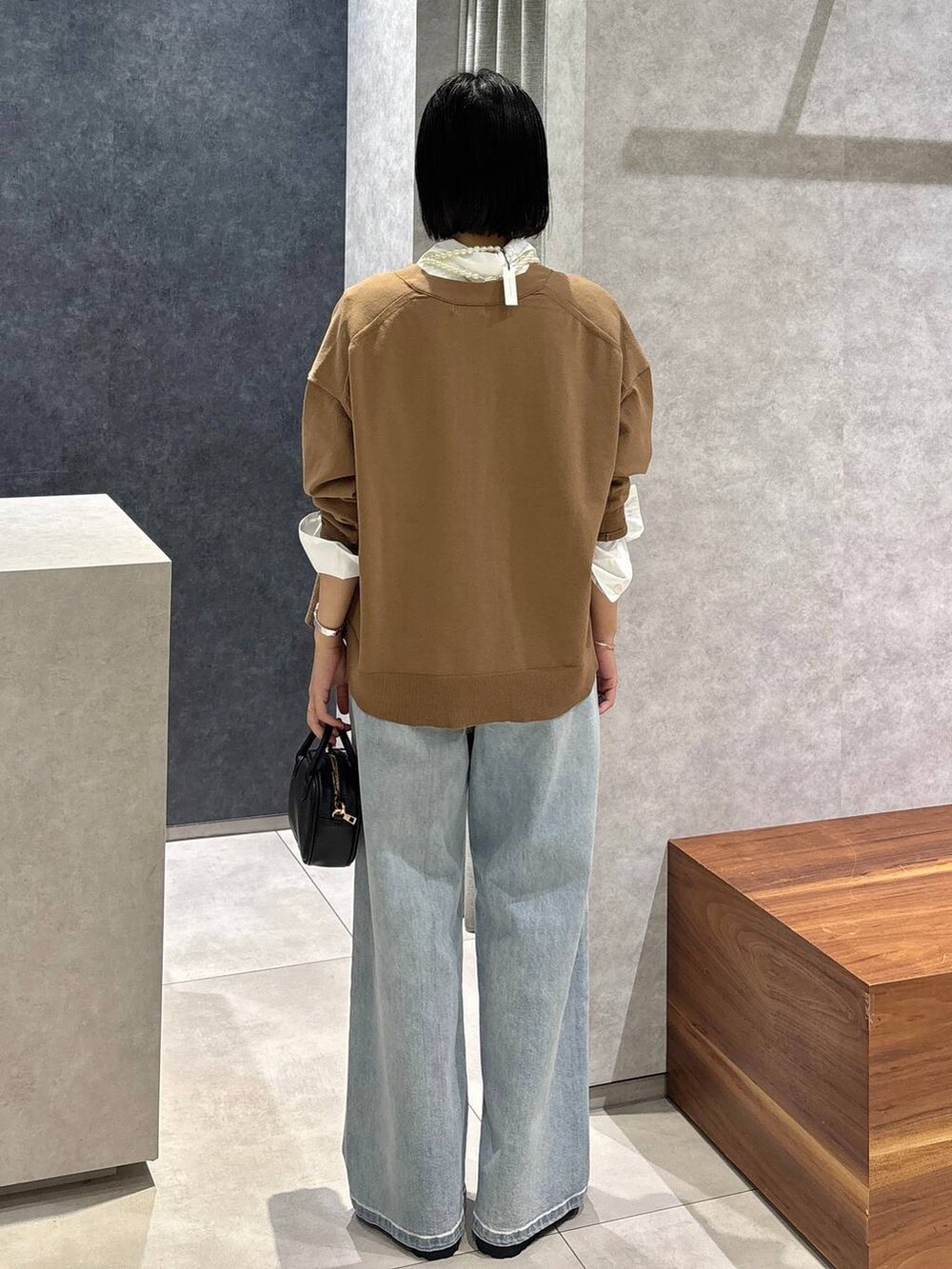 ブルー系のデニムパンツ、ブラック系のローファー、ホワイト系のシャツ/ブラウスを着用したレディースの夏コーディネートの4枚目の写真