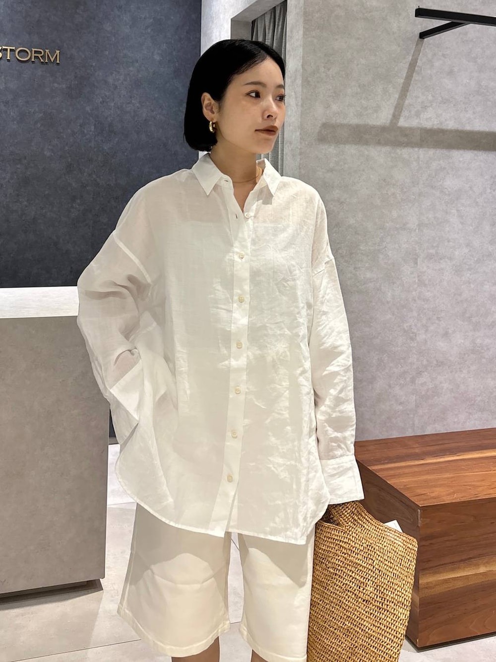 ブラウン系のトートバッグ、ブラック系のサンダル、ホワイト系のシャツ/ブラウスを着用したレディースの春コーディネートの8枚目の写真