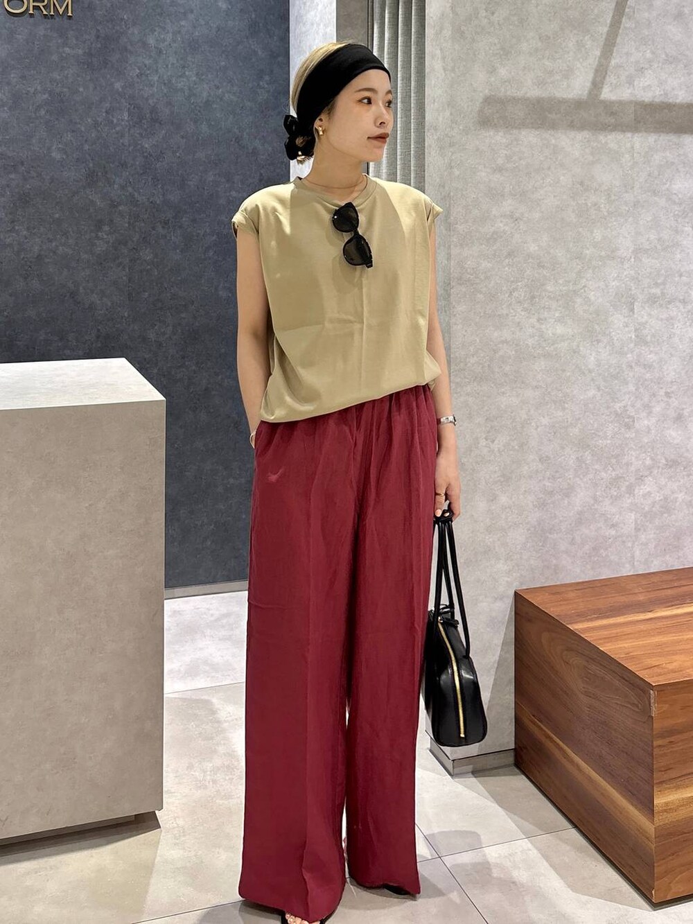 レッド系のその他パンツ、ベージュ系のTシャツ/カットソー、ブラック系のサンダルを着用したレディースの春コーディネートの4枚目の写真