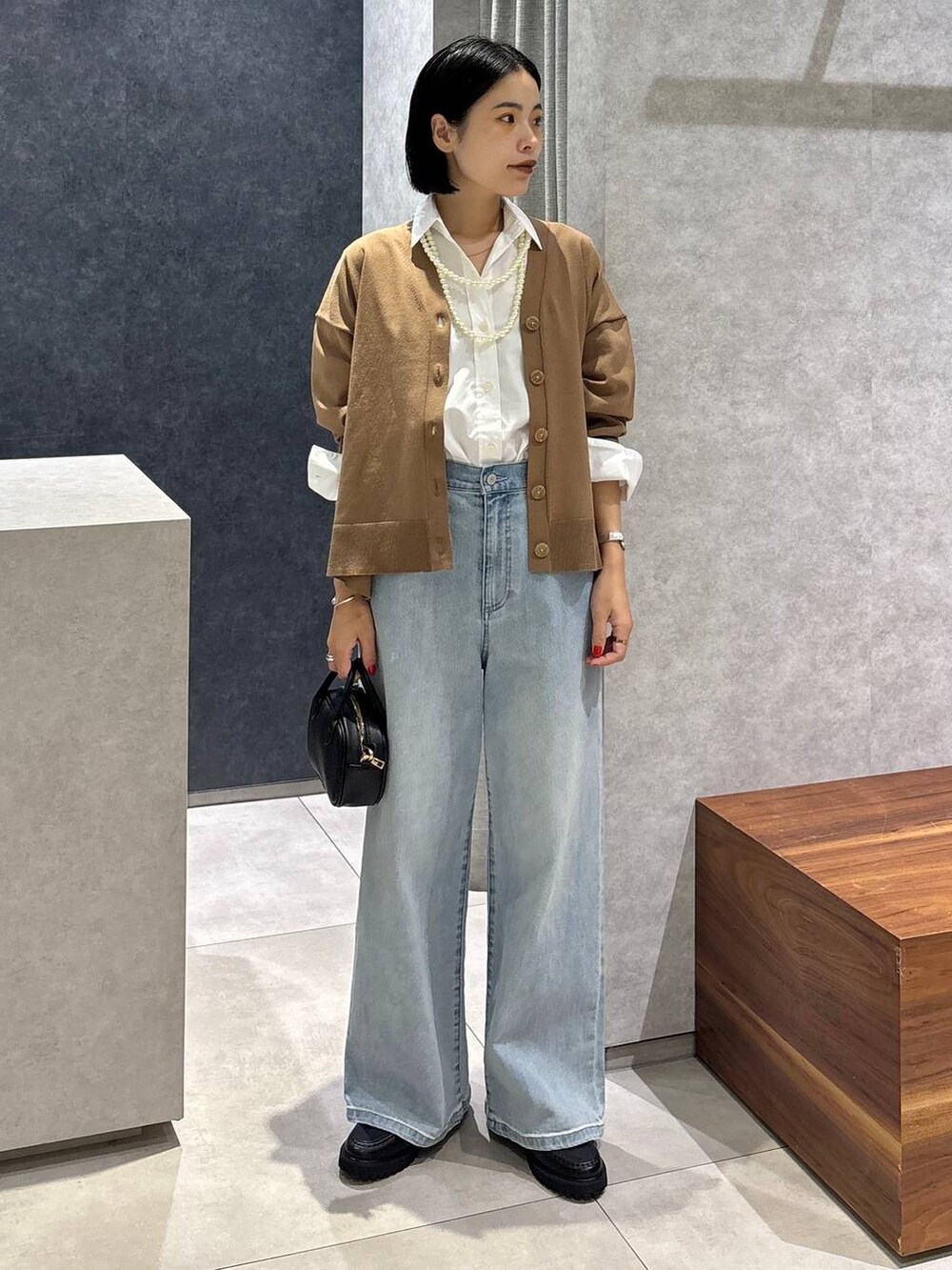 ブルー系のデニムパンツ、ブラック系のローファー、ホワイト系のシャツ/ブラウスを着用したレディースの夏コーディネートの8枚目の写真