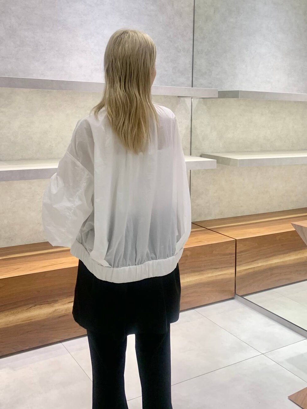 ブラック系のセットアップ、ホワイト系のブルゾン、ブラック系のパンプスを着用したレディースの夏コーディネートの3枚目の写真