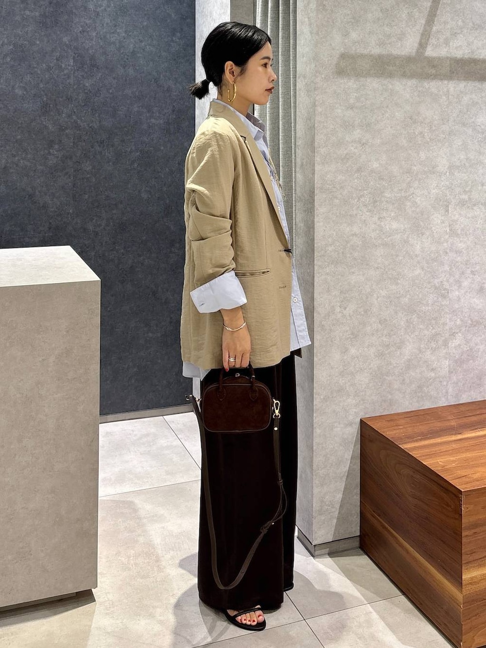 ベージュ系のテーラードジャケット、ブルー系のシャツ/ブラウス、ブラウン系のその他パンツを着用したレディースの夏コーディネートの2枚目の写真