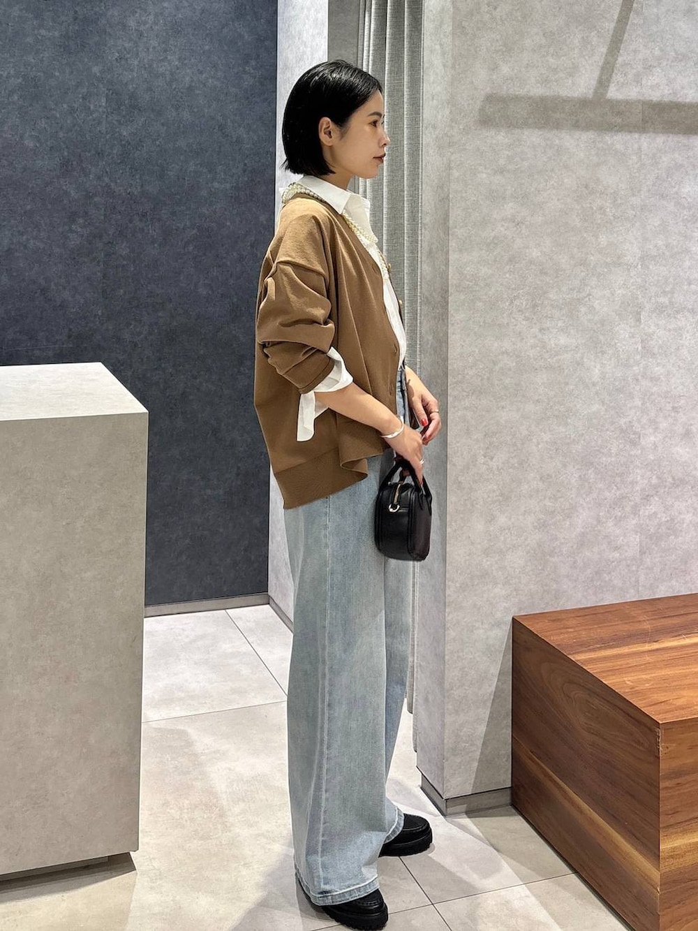 ブルー系のデニムパンツ、ブラック系のローファー、ホワイト系のシャツ/ブラウスを着用したレディースの夏コーディネートの2枚目の写真