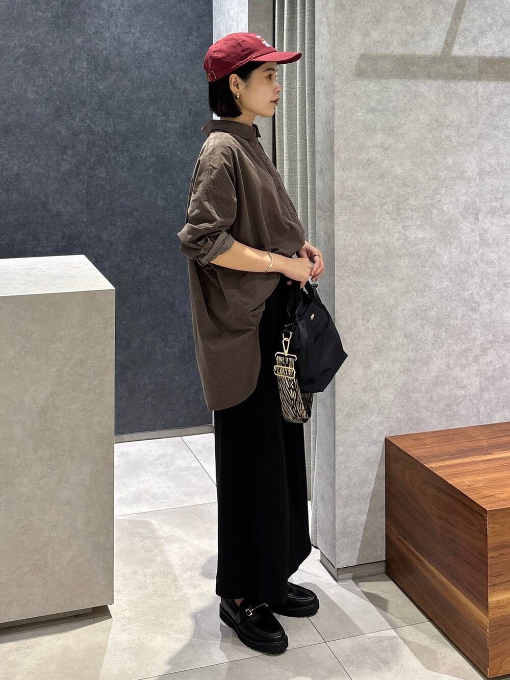 ブラック系のローファー、ブラック系のトートバッグ、ブラック系のスカートを着用したレディースの夏コーディネートの2枚目の写真