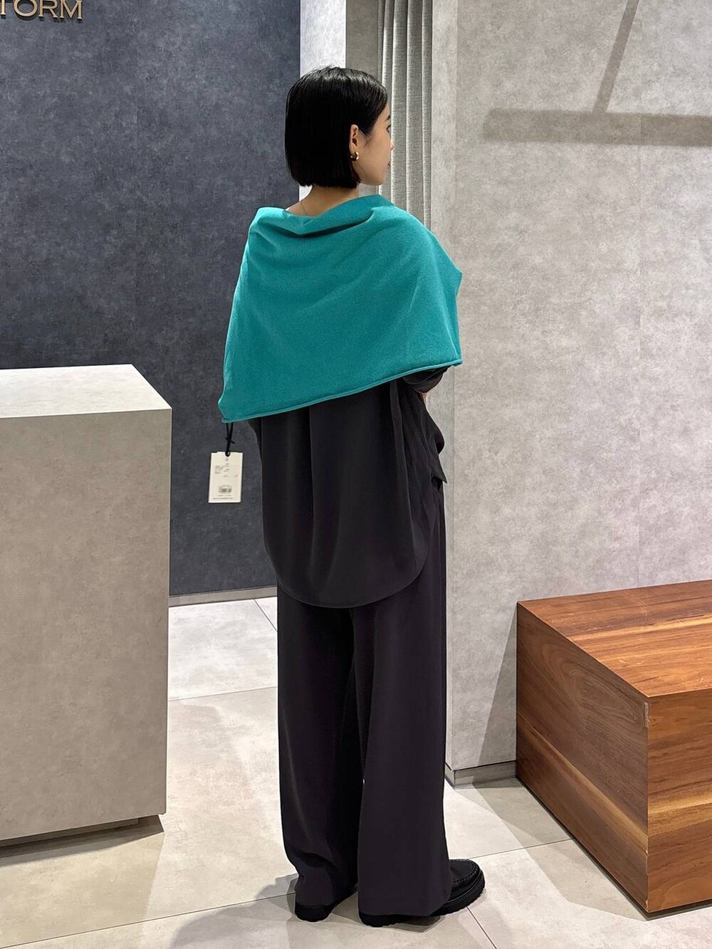 グレー系のシャツ/ブラウス、グレー系のスラックス、グリーン系のニット/セーターを着用したレディースの夏コーディネートの3枚目の写真