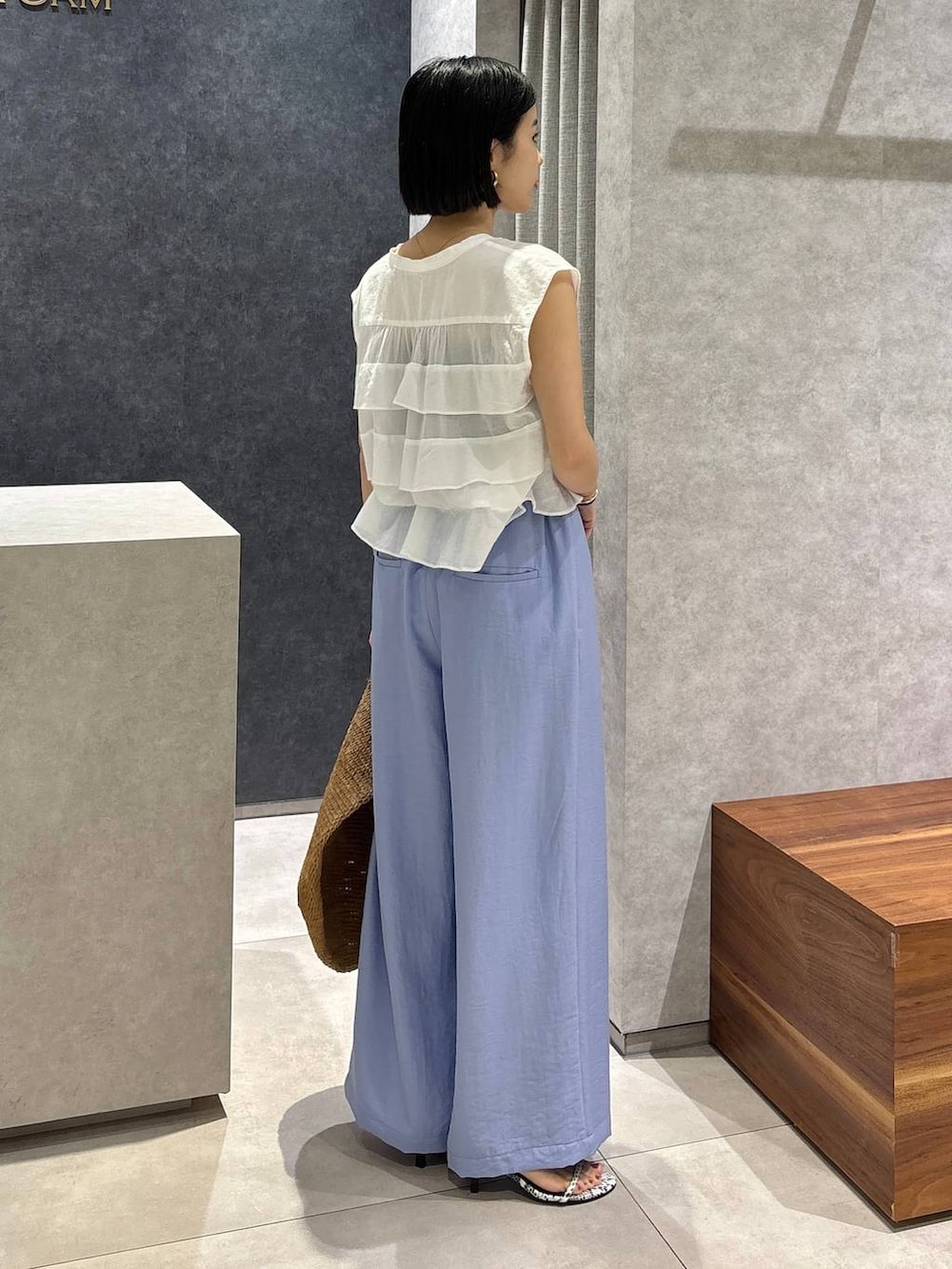 ブラウン系のトートバッグ、ブラック系のキャミソール、ブラック系のサンダルを着用したレディースの春コーディネートの2枚目の写真