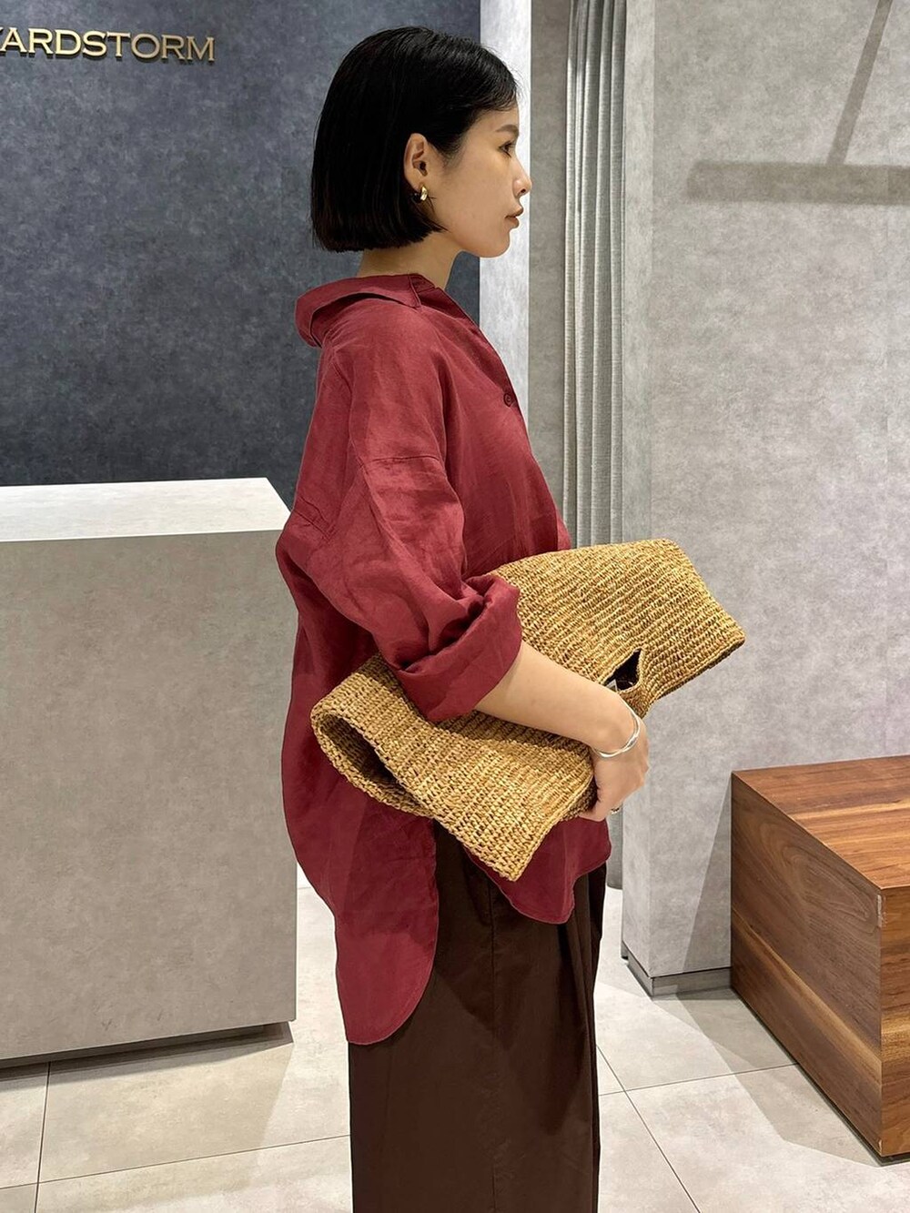 ブラウン系のその他パンツ、ブラウン系のトートバッグ、レッド系のシャツ/ブラウスを着用したレディースの春コーディネートの6枚目の写真