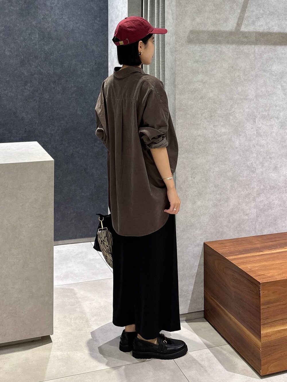 ブラック系のローファー、ブラック系のトートバッグ、ブラック系のスカートを着用したレディースの夏コーディネートの3枚目の写真