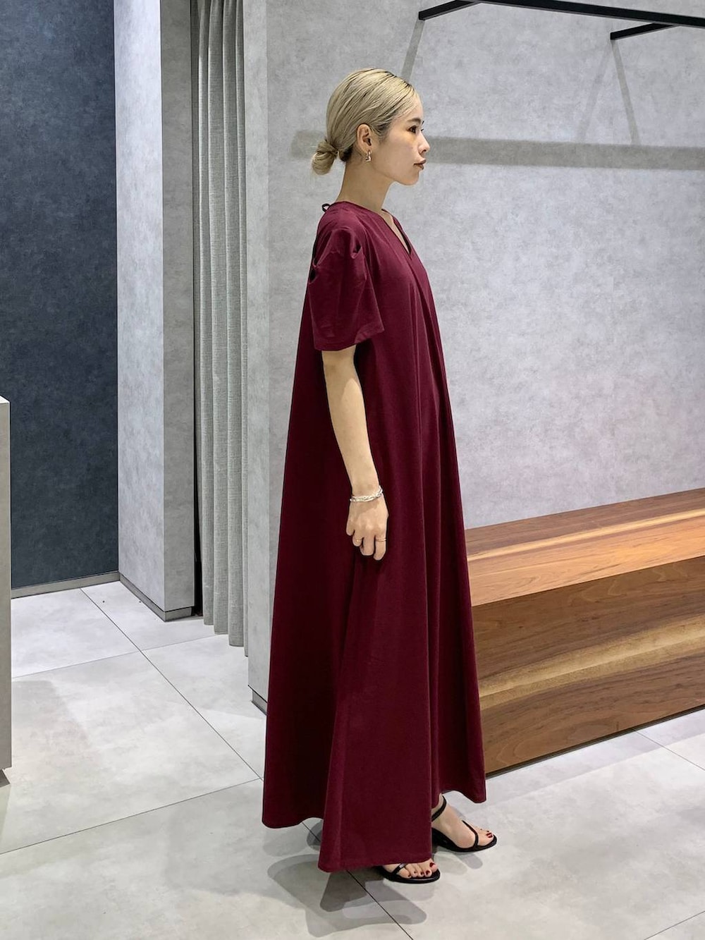 ブラック系のスリッポン、ブラウン系のハンドバッグ、レッド系のワンピースを着用したレディースの夏コーディネートの3枚目の写真